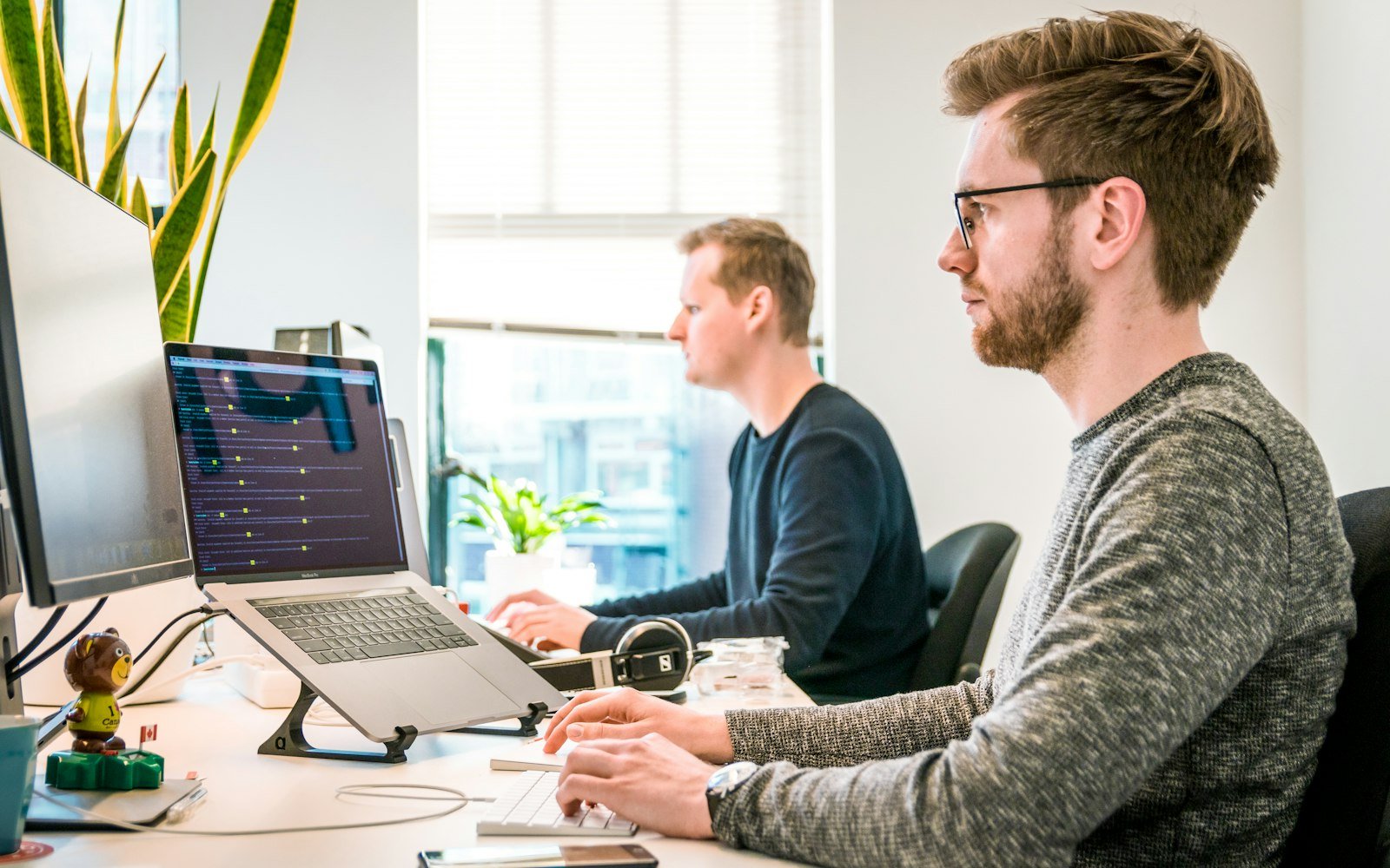 Consultants working at their desks with dashboards on screen