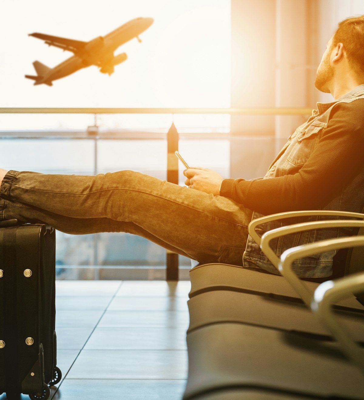 Traveller relaxing in an airport lounge as a plane takes off